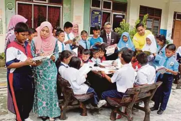  ?? PIC BY ESSA ABU YAMIN ?? Teachers helping their students with their schoolwork at SK Bakri
Batu 5 in Muar.