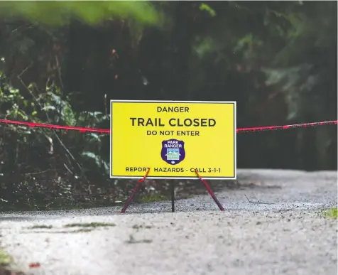  ?? NICK PROCAYLO/PNG ?? Warning signs are shown as the city's park board launches an education campaign about coexisting with coyotes after reports of coyotes chasing joggers and cyclists in Stanley Park. One person has been bitten.