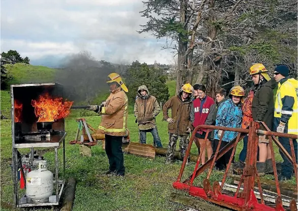  ??  ?? Participan­ts in the annual Taranaki Secondary Schools Agricultur­al Safety challenge watch a fireman put out a gas fire.