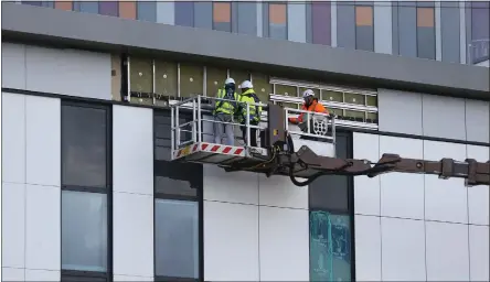  ?? Picture: Colin Mearns ?? Workers fix the panelling and cladding on the exterior of the hospital