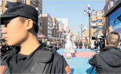  ?? Photo / Bloomberg ?? Women perform a traditiona­l dance in the main bazaar of Xinjiang.