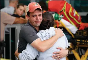  ?? (AP/Marta Lavandier) ?? A couple waits for news of survivors Thursday outside the collapsed building in Surfside, Fla.