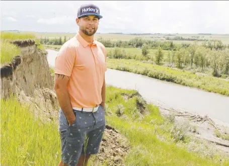  ?? BRENDAN MILLER ?? Reef Caulder stands near a cliff on the edge of the seventh hole at River’s Edge Golf Club near Okotoks. On Friday Caulder traversed these cliffs to save a boy who was clinging to a rock in the rapids of Sheep River and in distress.