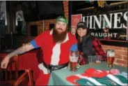  ?? NICHOLAS BUONANNO- NBUONANNO@TROYRECORD.COM ?? Saratoga City Tavern owner Jason Fitch dressed in Santa gear poses for a photo with his wife Marisa Fitch during the 11th annual Ugly Sweater Pub Crawl Saturday.