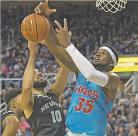  ?? TOM R. SMEDES/ASSOCIATED PRESS ?? Nevada forward Caleb Martin, left, and New Mexico forward Carlton Bragg battle for a rebound Saturday in Reno, Nev. The No. 6 Wolf Pack avenged its only loss of the season, blowing out the Lobos, 91-62.