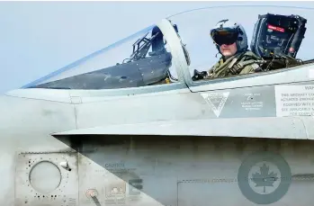  ?? ALBERTO PIZZOLI / AFP / GETTY IMAGES FILES ?? A Canadian CF-18 jet pilot from 3 Wing Bagotville, Que., sits in his plane upon arrival from a mission. The auditor general’s report warned Tuesday that Canada’s fighter jet capabiliti­es are being limited by a lack of trained pilots.