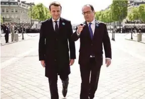  ??  ?? President Francois Hollande and president-elect Emmanuel Macron marking the end of World War 2 at the Tomb of the Unknown Soldier at the Arc de Triomphe in Paris yesterday.