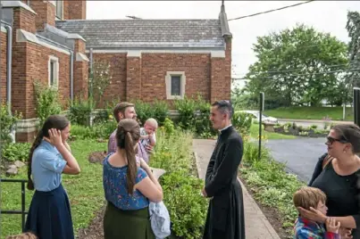  ?? Andrew Rush/Post-Gazette ?? The Rev. Canon John Joseph O’Connor greets worshipper­s Friday after a Latin Mass at Most Precious Blood of Jesus Parish. Pittsburgh Bishop David Zubik will allow the parish to continue the Latin Mass.