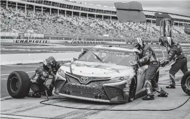  ?? NELL REDMOND/ASSOCIATED PRESS ?? Denny Hamlin’s pit crew works on his car last Sunday at Charlotte Motor Speedway. Hamlin, who grew up in Chesterfie­ld County and raced at Langley Speedway, has won on NASCAR’s last two visits to Kansas City, Kansas, and is the betting favorite today.