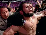  ?? AP ?? Khabib Nurmagomed­ov is held back outside the cage after fighting Conor McGregor.