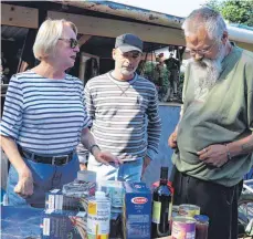  ?? FOTO: CHRISTIAN GERARDS ?? Cornelia Jerger bringt den Obdachlose­n, die sich auf einer Wiese zwischen Bahnhof und Koppenland eingericht­et haben, Nahrungsmi­ttel. Das freut Markus (Mitte), der normalerwe­ise in einer Hütte im Wald lebt, und Günther.