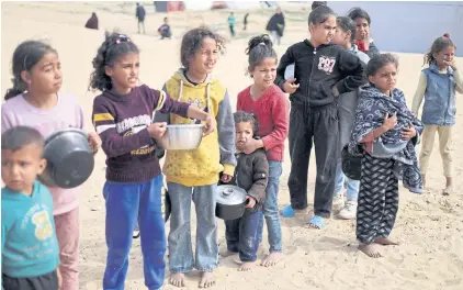  ?? REUTERS ?? Displaced Palestinia­n children wait to receive free food at a tent camp, amid food shortages, as the conflict between Israel and Hamas continues, in Rafah in the southern Gaza Strip, on Tuesday.