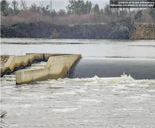  ?? S. GARCÍA ?? La barca en la que volcaron los fallecidos, encallada en el azud, ayer.