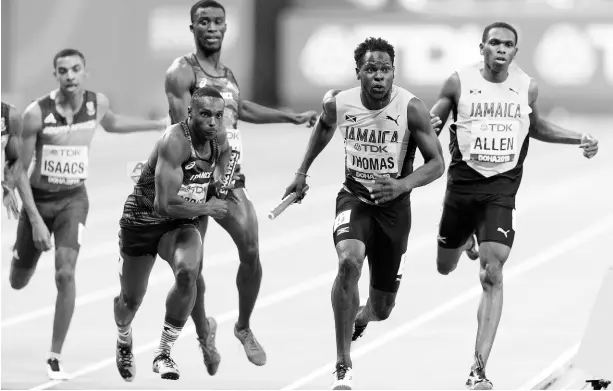  ?? GLADSTONE TAYLOR/MULTIMEDIA PHOTO EDITOR ?? Jamaica’s Nathon Allen (right) hands off the baton to teammate Terry Thomas (second right) for the third leg of the men’s 4x400m relay final at the World Athletics Championsh­ips at the Khalifa Internatio­nal Stadium in Doha, Qatar, on Saturday, October 5, 2019. Both athletes have ambitions of representi­ng Jamaica at the next Olympic Games if the event goes ahead without any issues, but this is threatened by the global COVID-19 pandemic.