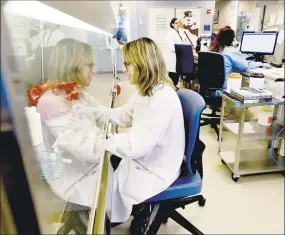  ?? Peter Hvizdak / Hearst Connecticu­t Media ?? Yale New Haven Hospital medical technologi­st Nicole Dubreuil of the Yale Clinical Virology Lab, left, processes samples for Covid-19 / Coronaviru­s testing at Yale New Haven Hospital in New Haven on Thursday.