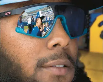  ?? FRANK GUNN/THE CANADIAN PRESS VIA AP ?? The Blue Jays’ Ricky Tiedemann is reflected in the glasses of Vladimir Guerrero Jr. in the dugout before a spring training game against the Rays on Feb. 28 in Dunedin, Florida.