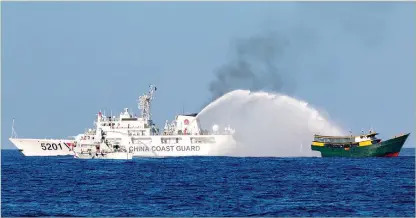  ?? PHOTO: REUTERS ?? Below: Chinese Coast Guard vessels fire water cannons towards a Philippine resupply vessel Unaizah on its way to a resupply mission at Second Thomas Shoal in the South China Sea.