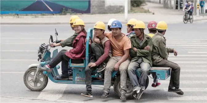  ??  ?? CHANGPING: Workers ride on a motor tricycle to go to a constructi­on site in Changping, on the outskirts of Beijing. — AFP