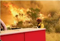  ?? AP ?? Los Angeles County firefighte­rs fight the flames in Placenta Caynon Road in Santa Clarita, California. —