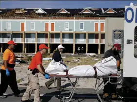  ?? AP PHOTO/DAVID GOLDMAN ?? A body is removed after being discovered during the search of a housing structure in the aftermath of hurricane Michael in Mexico Beach, Fla., on Friday.