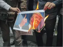  ?? VAHID SALEMI THE ASSOCIATED PRESS ?? Demonstrat­ors burn a picture of President Donald Trump during a protest in front of the former U.S. Embassy in Tehran, Iran, Wednesday.