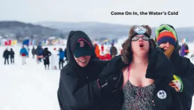  ??  ?? Sam Levinson celebrates as she is wrapped up and escorted to the warming hut by her teammates from the L-Street Brownies after competing in the 200-metre race