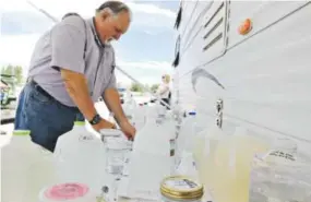  ??  ?? New Mexico Environmen­t Department District Manager Bob Italiano places bottles of water for testing on a table Monday. Alexa Rogals, The Daily Times