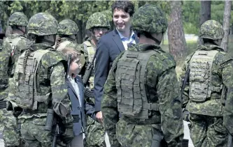  ?? ADRIAN WYLD/THE CANADIAN PRESS ?? Prime Minister Justin Trudeau and his son Xavier review an honour guard as they arrive at the Internatio­nal Peacekeepi­ng and Security Centre in Yavoriv, Ukraine in 2016. Trudeau has finally unveiled Canada’s long-awaited commitment to United Nations...