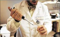  ?? BRANDON KRUSE / THE PALM BEACH POST 2009 ?? A researcher at Scripps Florida prepares to examine a fruit fly brain under a microscope. Neuroscien­tist Ron Davis has been studying the science of memory.