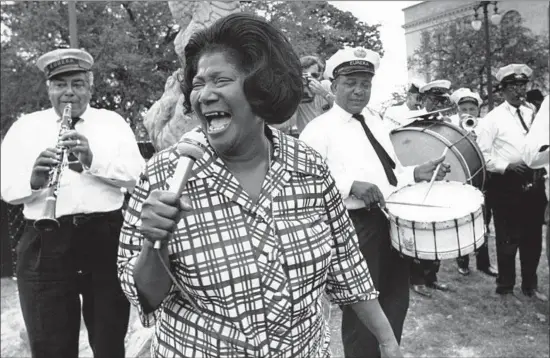  ?? Associated Press ?? SINGER Mahalia Jackson, a native of New Orleans, holds an impromptu performanc­e with the Eureka Brass Band at the 1970 New Orleans Jazz & Heritage Festival.