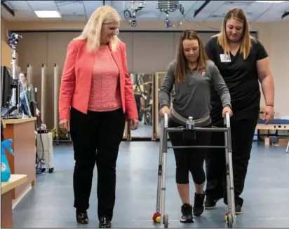  ?? Tom Fougerouss­e/University of Louisville — The Washington Post ?? Susan Harkema, left, associate scientific director of the Kentucky Spinal Cord Injury Research Center at the University of Louisville, with Kelly Thomas, who was paralyzed in a car accident and is learning to walk with the help of a trainer and an implanted device.