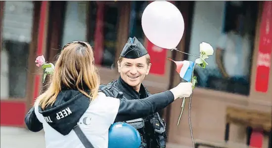  ?? GEOFFROY VAN DER HASSELT / AFP ?? Una dona saluda un agent en una marxa organitzad­a als Camps Elisis en suport de la policia després de l’atemptat de dijous