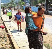  ?? (Free Burma Rangers via AP) ?? In this photo released by the Free Burma Rangers, families flee after a Buddhist monastery sheltering civilians displaced by fighting in the town of Papun, Karen state, Myanmar, was attacked on March 31 by a regime warplane.