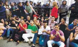  ??  ?? Alban mourners shout slogans in front of riot policemen standing outside the headquarte­rs of Bolivarian National Intelligen­ce Service in Caracas on Monday.