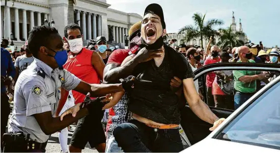  ?? Yamil Lage - 11.jul.21/AFP ?? Manifestan­te contrário ao regime liderado por Miguel Díaz-Canel é detido por policiais durante protesto em Havana