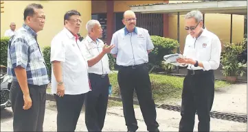  ??  ?? Miri District Education Of cer Dr Hassan Hasbollah (third left) updating Ali on the latest developmen­t of SK Kampung Luak while Ahmad Zaki (right) and others are listening.