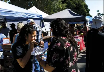  ?? PHOTO VINCENT OSUNA ?? Brawley residents Lexi Mendez, 12, (left) and Nancy Calleros enjoy some ribs during the Brawley Elks Lodge’s second annual Oktoberfes­t Rib CookOff held Saturday afternoon on South Plaza Street in Brawley.