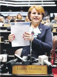  ?? FUENTE EXTERNA ?? La diputada Lucía Medina muestra una factura para avalar que pagó por las mochilas que donó a estudiante­s a través de la fundación que maneja y que se ha alegado pertenecía­n al Ministerio de Educación.