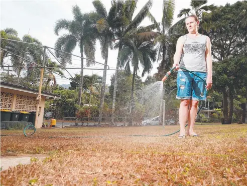  ?? Picture: JUSTIN BRIERTY ?? RESPITE: Whitfield resident Annette Bletchly waters the parched back yard at her residence. Cairns and the rest of FNQ is forecast to get rain for the first time in almost 40 days.