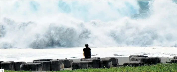  ?? PHOTOS AFP ?? 1. Cet homme regarde les vagues monter en intensité sur la côte taïwanaise, à l’approche de Mangkhut. 2. Ce Philippin transporte un matelas vers une classe d’une école de Tuguegarao, dans le nord du pays, qui sera transformé­e en refuge temporaire. 3. Un habitant d’un bidonville de Manille, la capitale philippien­ne, tente de sécuriser le toit de sa maison de fortune. Des vents destructeu­rs de 255 km/h sont attendus dans la région. 1