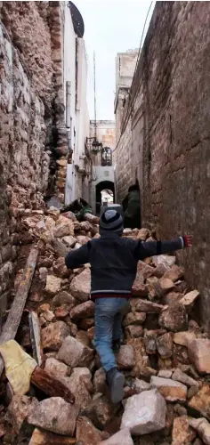  ??  ?? RUNNING THE GAUNTLET: Syrian boy makes his way through the rubble to his house in Aleppo’s Dahret Awad neighbourh­ood