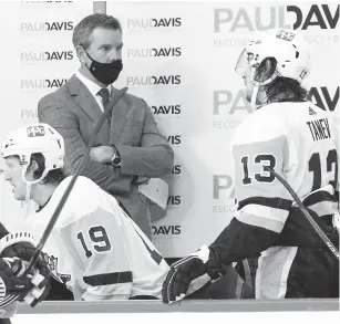  ?? CHRIS SZAGOLA/ASSOCIATED PRESS ?? Pittsburgh Penguins head coach Mike Sullivan speaks with defenseman Chris Tanev during Wednesday’s season opener at Philadelph­ia. The Flyers won 6-3.