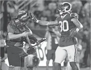  ?? ROBERT HANASHIRO/ USA TODAY SPORTS ?? Rams running back Todd Gurley covers a TV camera lens after scoring a touchdown in the second quarter Sunday night against the Bears at Los Angeles Memorial Coliseum.