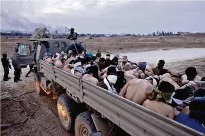  ?? (GAZA, 8 DÉCEMBRE 2023/MOTI MILROD, HAARETZ/AP PHOTO) ?? Un camion de l’armée israélienn­e déplaçant des détenus palestinie­ns, aux yeux bandés.