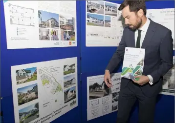  ??  ?? MinisterEo­ghan Murphy viewing the display of McCall’s Cottages, one of the award nominees