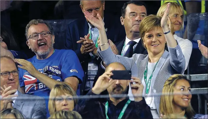  ??  ?? Best of enemies: First Minister Nicola Sturgeon gets behind Team GB at the Emirates Arena in Glasgow yesterday, alongside Conservati­ve Scottish Secretary David Mundell