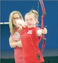  ??  ?? Tonya Raborn, archery coach and PE teacher at Pine Forrest Elementary in Maumelle, watches as Bailey Mason eyes a shot during a practice round June 6.