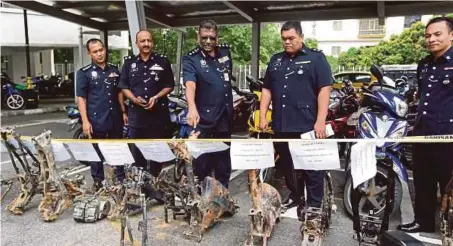  ??  ?? MUNUSAMY (tengah) bersama pegawainya menunjukka­n rangka motosikal pada sidang media di Ibu Pejabat Polis Daerah Sentul.