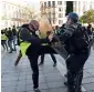  ?? AFP ?? A protester wearing a “yellow vest” tries to kick a policeman during a demonstrat­ion at Nantes in France on Saturday. —