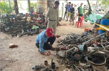  ?? CMAC ?? An official from the Cambodian Mine Action Centre (CMAC) inspects a workshop in Kandal province where the head of a 105mm shell exploded, killing a man who was working with it.